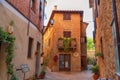 Pienza, Italy Ã¢â¬â May 27, 2017: Beautiful narrow street with sunlight and flowers in the village of Pienza, Italy Royalty Free Stock Photo